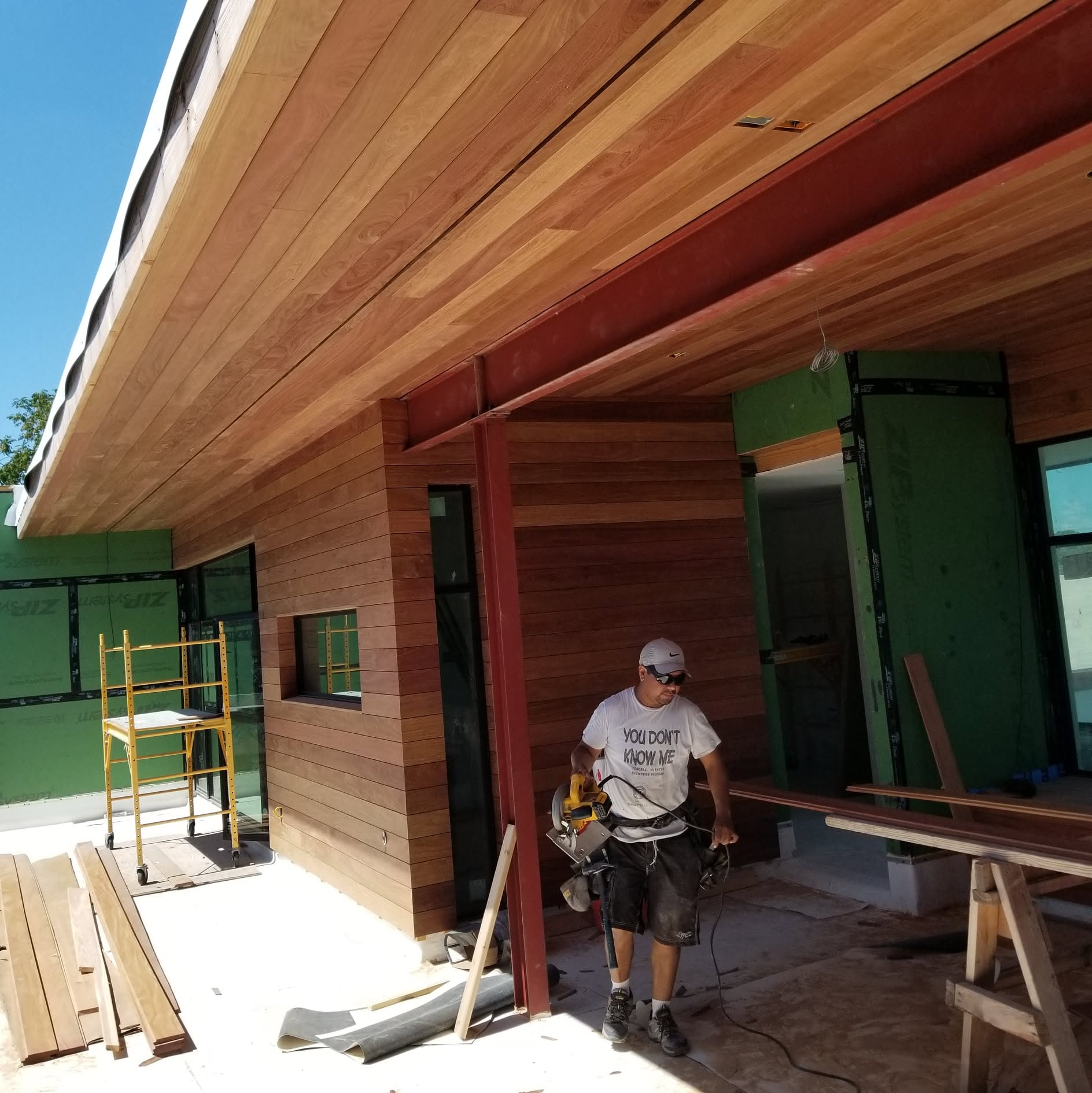 Craftsperson working beneath a cedar-clad patio ceiling with wood walls