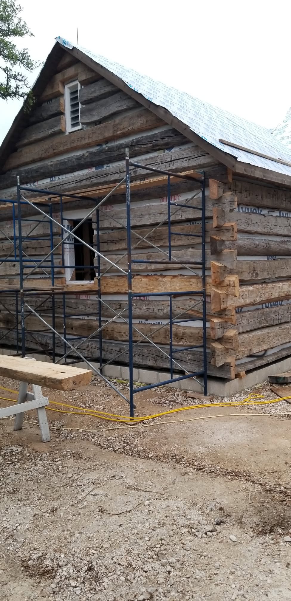 Exterior corner of a log structure with scaffolding and roof sheathing