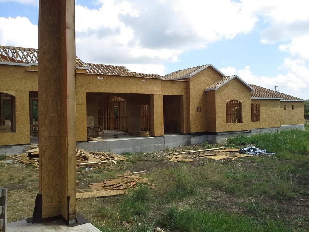 Wide view of a framed roofline and sheathed exterior walls under construction