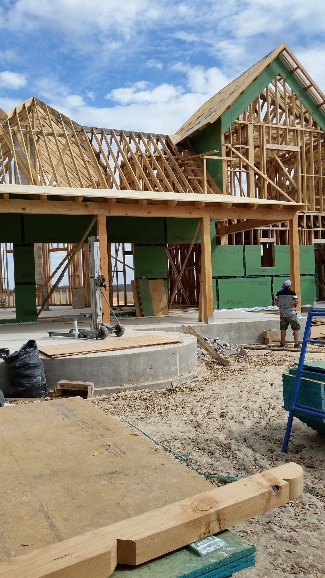 Covered back patio and adjoining roof structure during framing