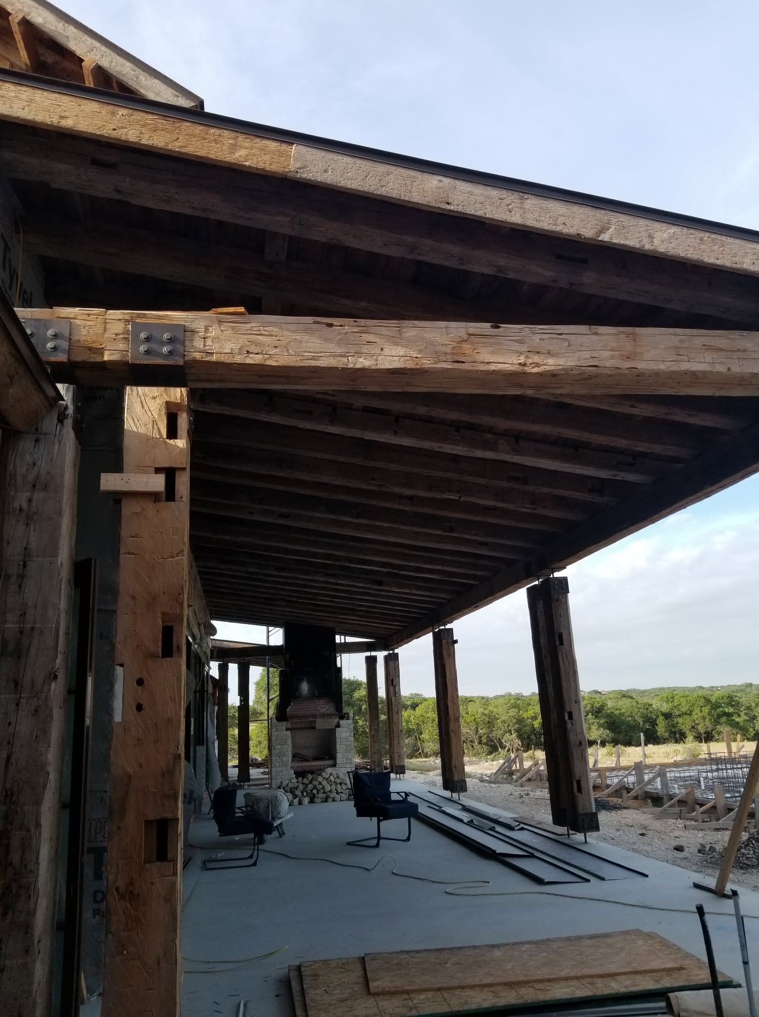 Covered patio supported by large reclaimed timber beams and posts