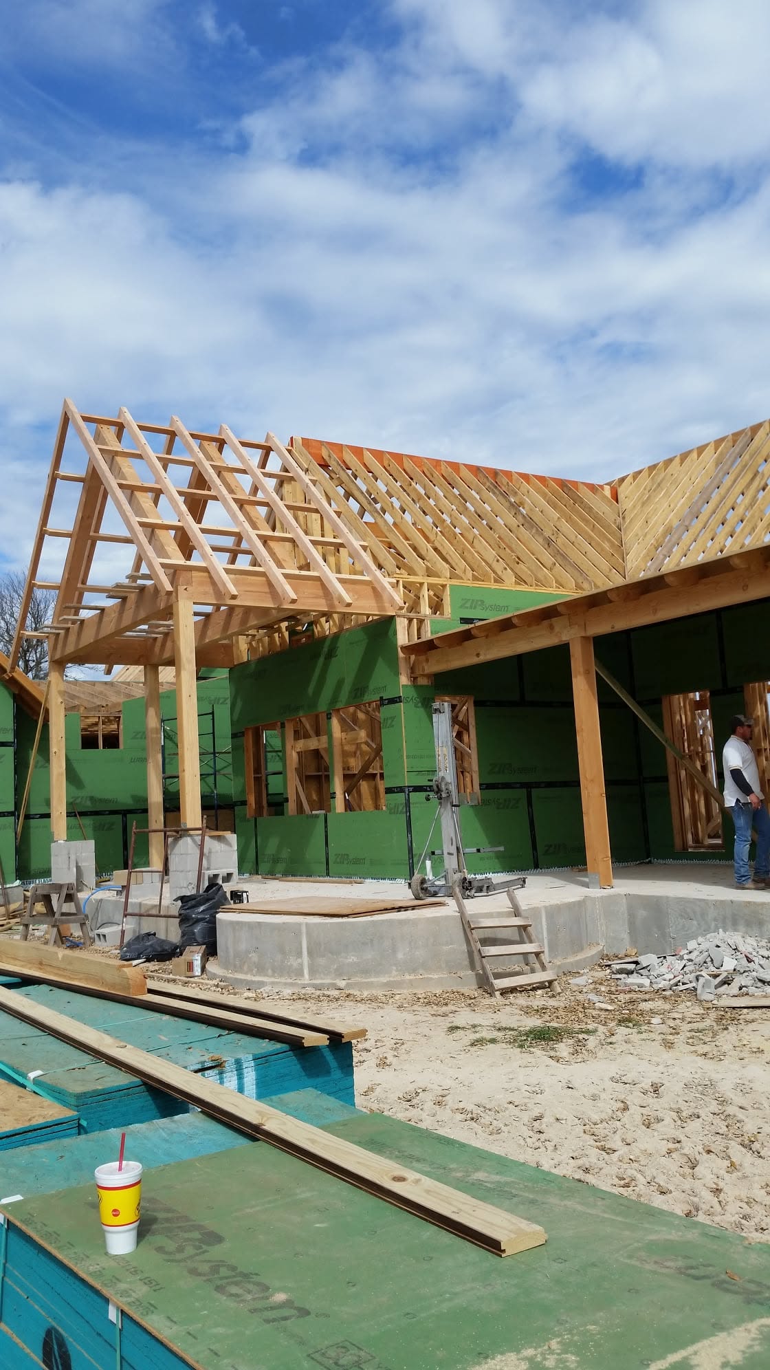Tall open roof framing above a covered patio structure under construction