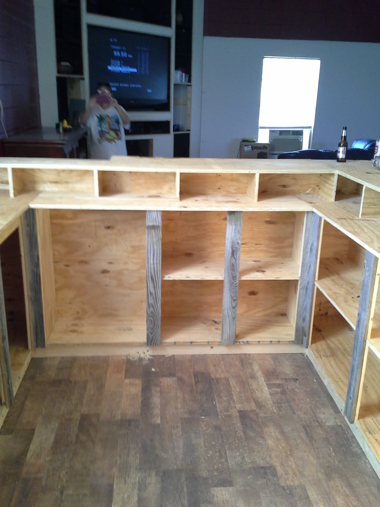 Interior view of a wood-framed bar with open shelves and counter framing