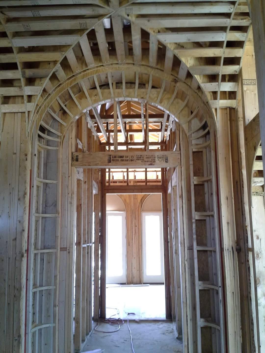 Tall curved interior archway formed with closely spaced wood framing