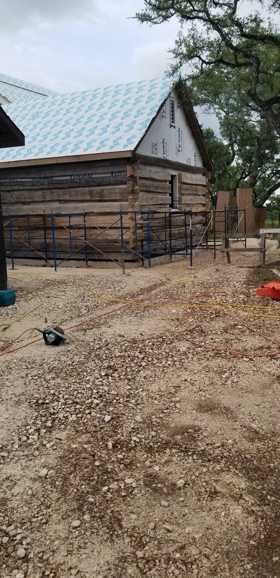 Log structure under construction with roof sheathing and scaffolding