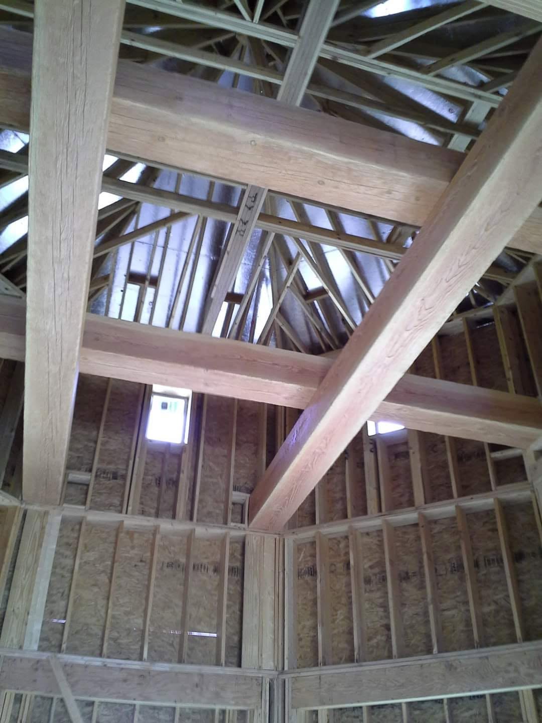 Large redwood beams crossing a tall framed interior