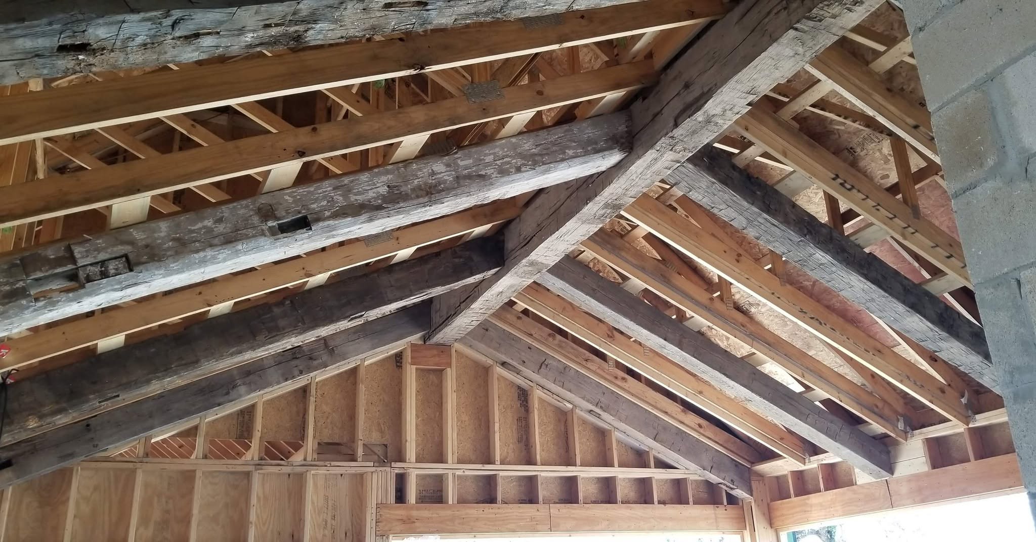 Weathered reclaimed timber beams within new roof framing